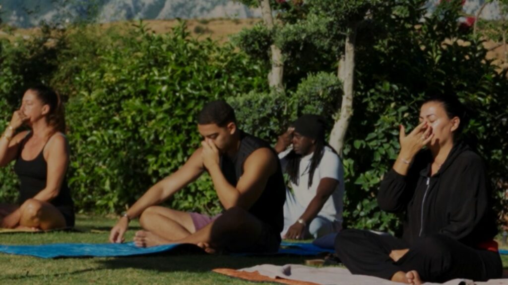 Participants de la retraite Nio Far en séance de méditation et de respiration en plein air à Datça, en Turquie